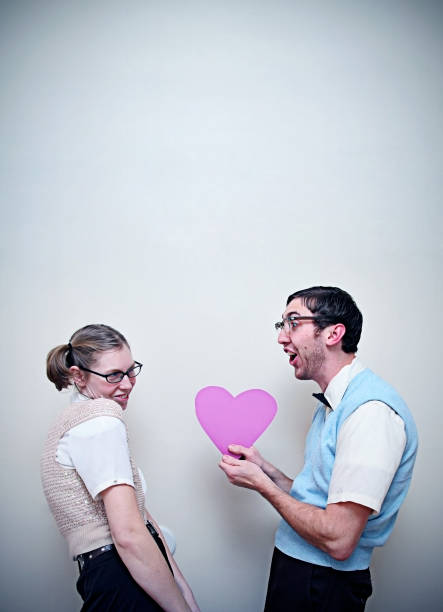 bel nerd ragazzo e ragazza in amore dare un cuore - valentines day love nerd couple foto e immagini stock