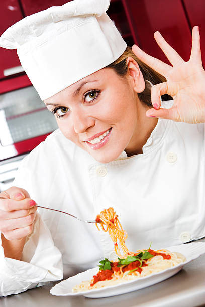 Young female cook having fun in a kitchen stock photo