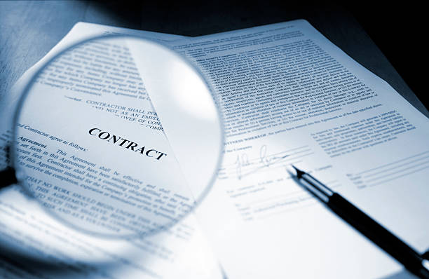 magnifying glass examining signed legal contract - kontrakt bildbanksfoton och bilder