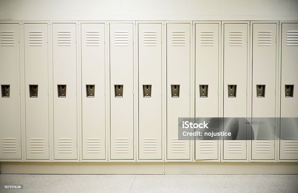 Row of tall white lockers in a white corridor A row of lockers in a high school Locker Stock Photo