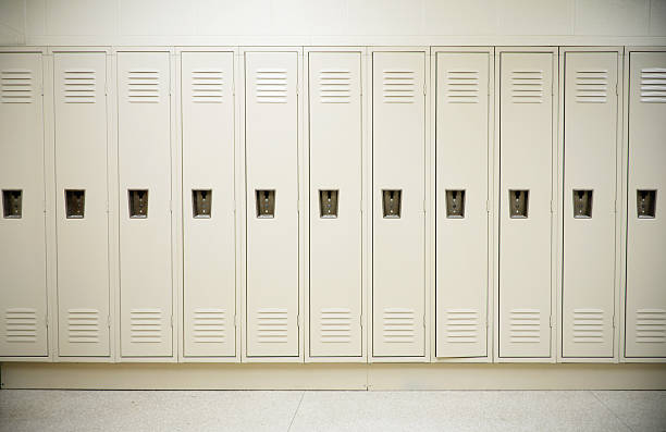 Row of tall white lockers in a white corridor stock photo