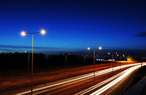 Twilight image of the Manchester, UK, M60 orbital motorway with light trails from vehicles painting a vivid image across the screen.