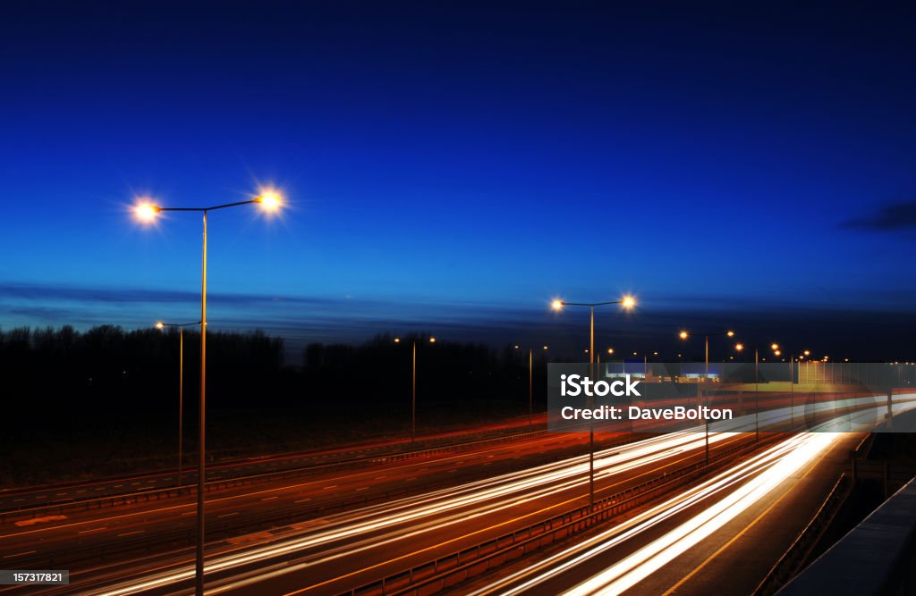 Manchester Rush Hour at Dusk with Traffic Trails Twilight image of the Manchester, UK, M60 orbital motorway with light trails from vehicles painting a vivid image across the screen. Multiple Lane Highway Stock Photo