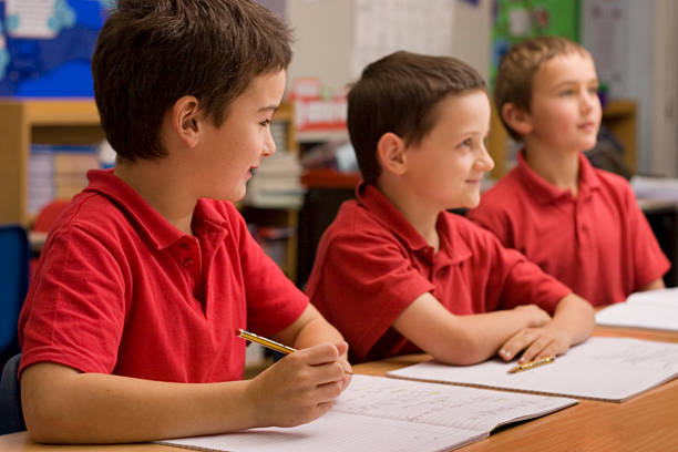 istock Three boys listening in classroom 157317980