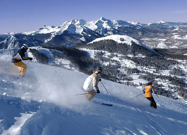 Photo of Three friends skiing fresh powder