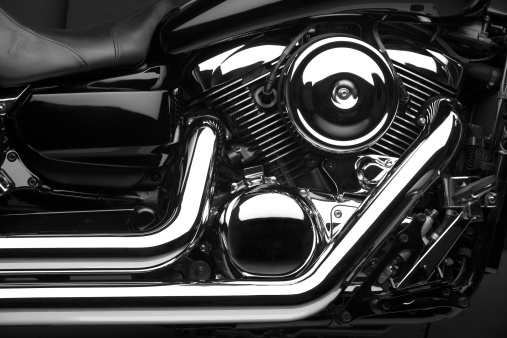Closeup shiny chrome details of modern motorcycle motor parked in garage in daytime