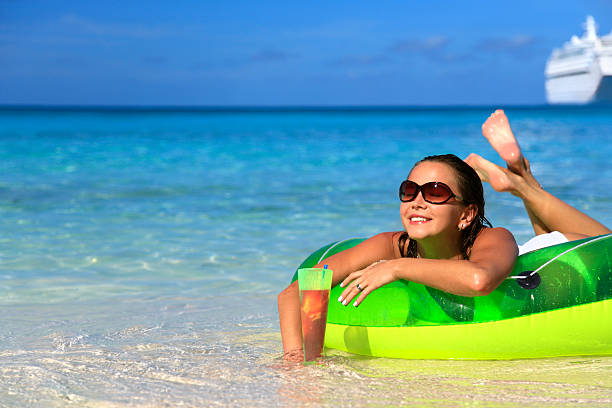 istock woman enjoying a drink on the beach 157318127