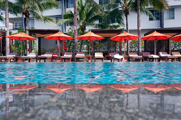 Lounge chairs and umbrellas poolside at a tropical resort