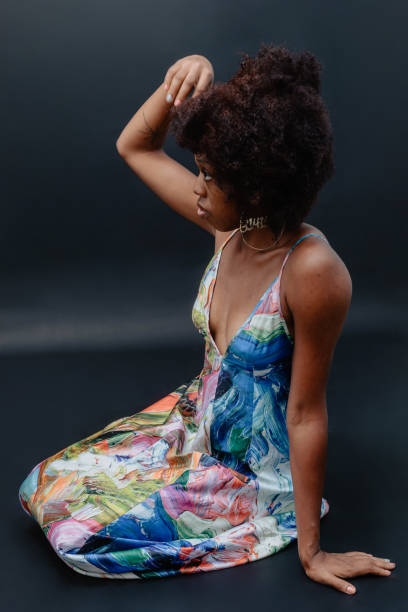 istock Side Profile Of Woman Sitting Down Touching Her Afro 1573211383