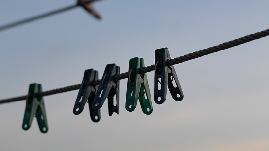 silhouette of clothes hanger pin hanging on clothesline in the afternoon