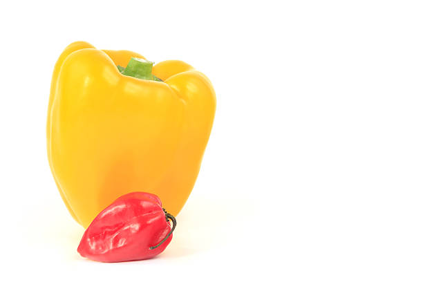 Yellow bell pepper and red habanero chili isolated against  a white background