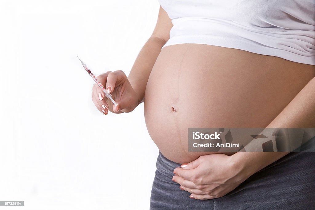 Pregnancy diabetes Pregnant woman with syringe, isolated on white Abdomen Stock Photo