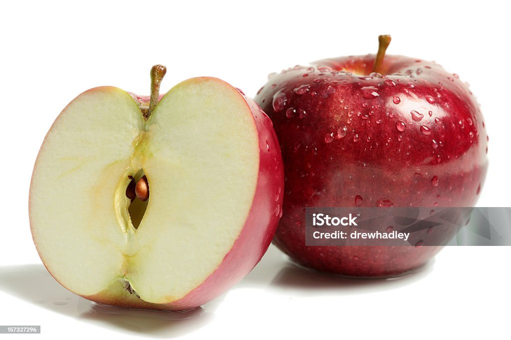 Two rosy red apples with one halved on white surface Cross section of red apple, showing pips, and core, with water droplets. Isolated on white, macro. XXL. Apple - Fruit Stock Photo
