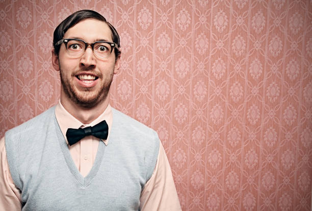 Nerd Student With Retro Glasses and Pink Wallpaper Nerdy IT young man makes a goofy face with pink copy space background. Horizontal. nerd stock pictures, royalty-free photos & images