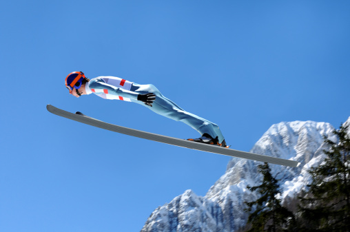 Skiing in action. Sportsman in a red ski suit. Side view. High speed. Isolated. Sport