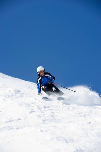 istock Young Boy wearing helmet while snow skiing 157328569