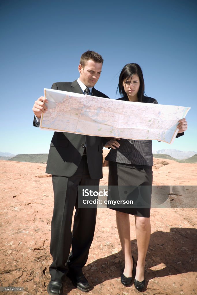 We're Lost A couple of business people lost in the desert consult their map. Road Map Stock Photo