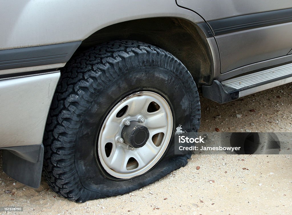 A flat tire deflating on an unpaved road Flat tyre on 4WD. Tire - Vehicle Part Stock Photo