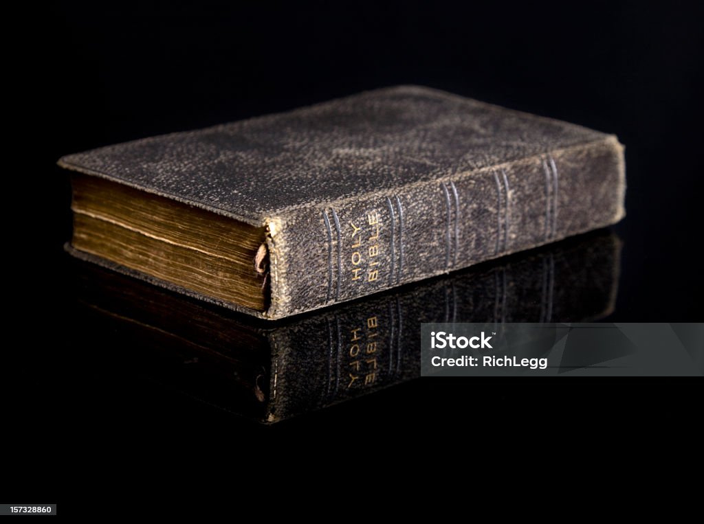 Bible on Black An antique bible on a black reflective surface. Bible Stock Photo