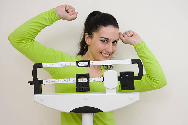 istock woman on weight scale 157329230