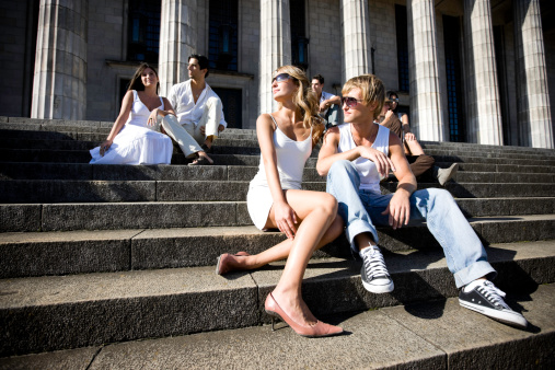 group of students relaxing in the sun in front of the Buenos Aires university building.