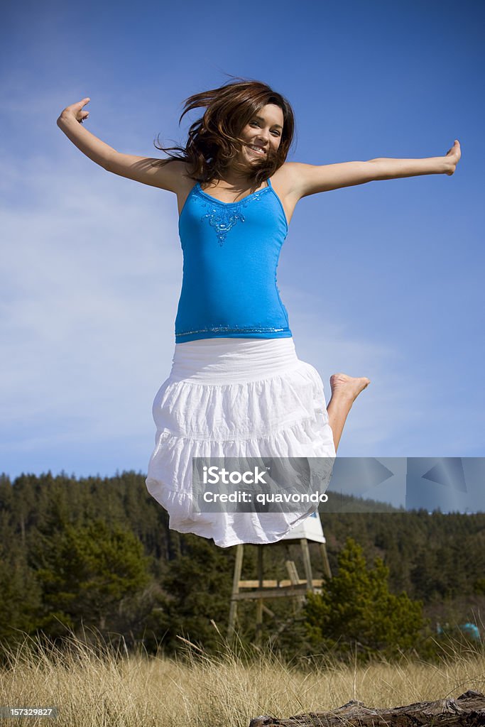 Brunette hermosa mujer joven saltar en el aire libre - Foto de stock de Mujeres libre de derechos