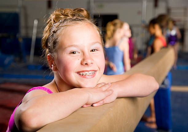 mulher jovem ginasta em uma academia de ginástica - balance beam - fotografias e filmes do acervo