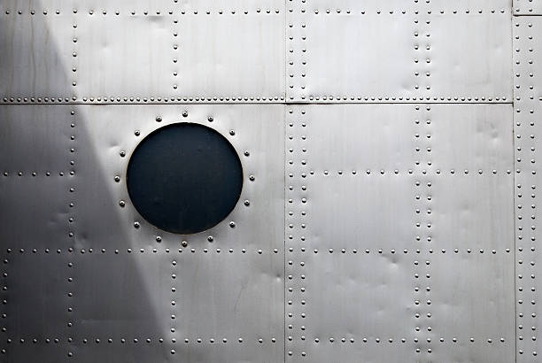 istock Aircraft siding with circular window and rows of rivets 157329900