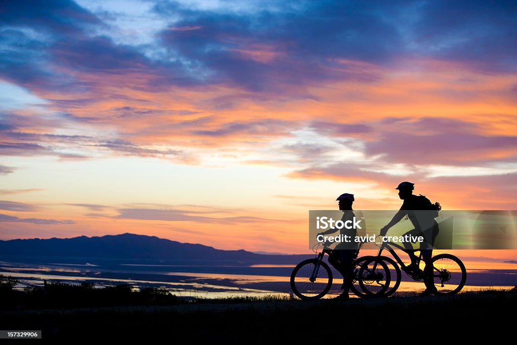 Du VTT Couple profitant de la vue sur le coucher de soleil - Photo de Faire du vélo libre de droits