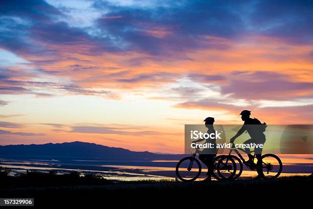 Foto de Mountain Biking Casal Desfrutando De Vista Do Pôrdosol e mais fotos de stock de Ciclismo