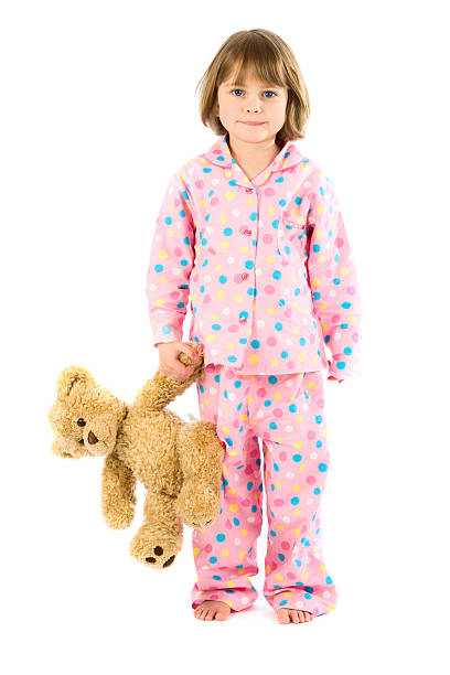 istock Young girl in pajamas with teddy bear on white 157330181