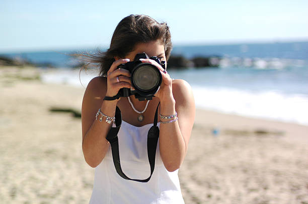istock Female Photographer Looking Through A DSLR Camera 157330252