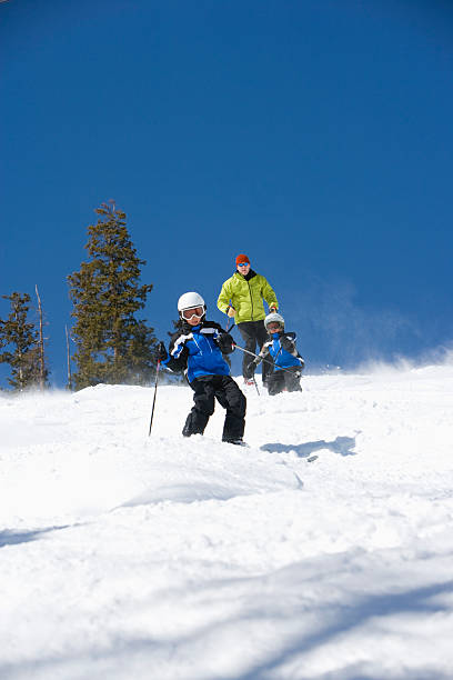 istock Father and two sons skiing together 157330791