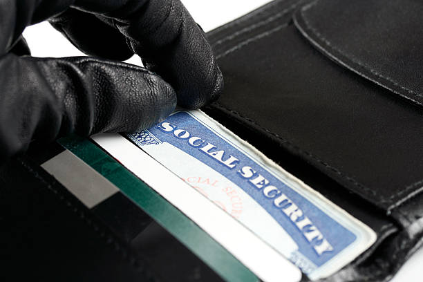 Identity Theft A gloved hand reaches for a social security card in a wallet. Identification and CaptureMonster Black Market stock pictures, royalty-free photos & images
