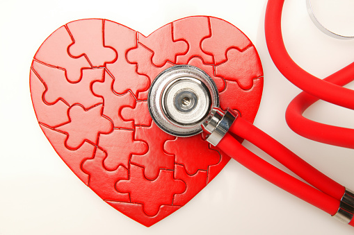 heart shape puzzle and stethoscope listening to heartbeat