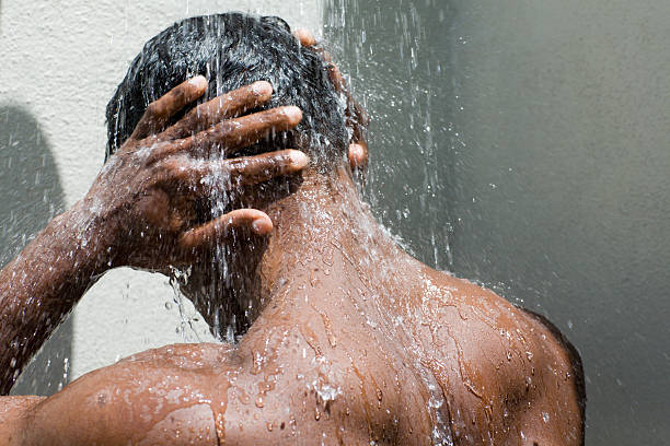 hand and head under the shower stock photo