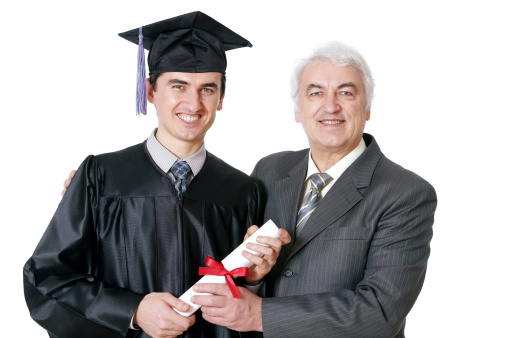 Man in a graduation gown holding a diploma and showing thumbs up isolated on white background