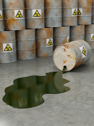 A rusty damaged waste barrel spilling oil on the ground. Very high resolution 3D render.