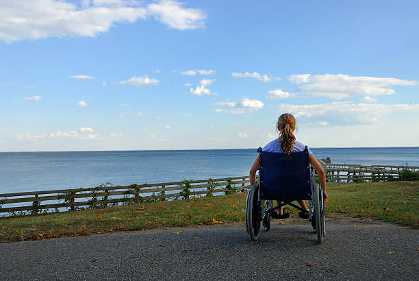 A woman in a whelk chair dreaming she could swim stock photo