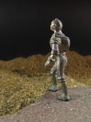 A close up studio shot of a 1960's astronaut figure(cast metal,5cm tall).Traces of original green paint are visible.Focus on head.