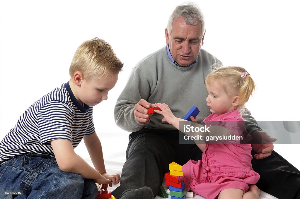 Abuelo y nietos jugando - Foto de stock de 50-59 años libre de derechos