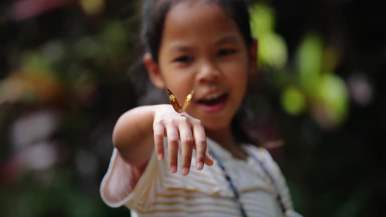 Beautiful butterfly flapping wings on kid hand in the forest