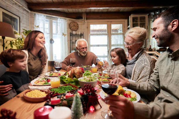 istock Happy extended family talking during lunch in dining room. 1573328281