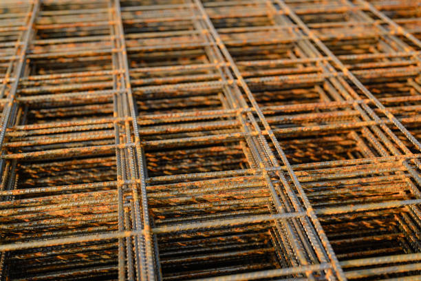 istock Stack of welded wire mesh, WWM, ready to be installed within a sidewalk concrete form. 1573329398