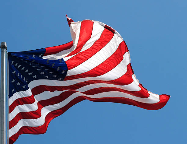 istock American Flag From a Pole  Isolated on Blue 157333505