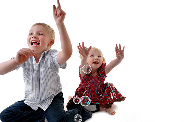 istock brother and sister playing with bubbles 157333795