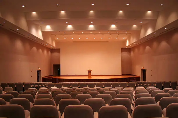 Photo of Empty auditorium with grey seats and downlights