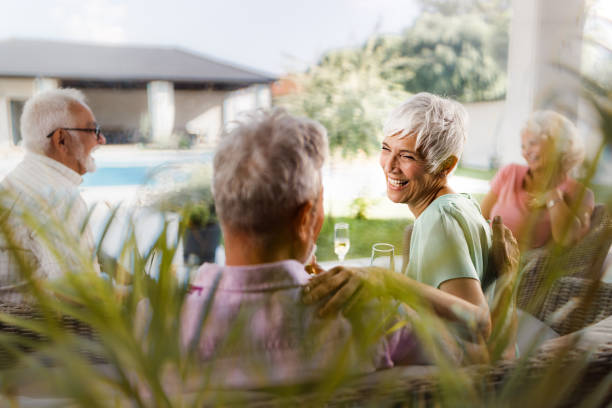 istock Senior couples relaxing during social gathering on a patio. 1573342632