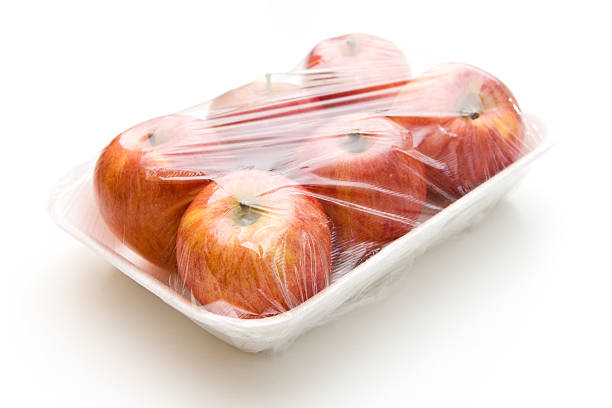 Six apples cling wrapped to a Styrofoam tray stock photo