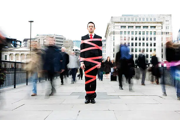 Photo of London business man tied up in bureaucracy and red tape
